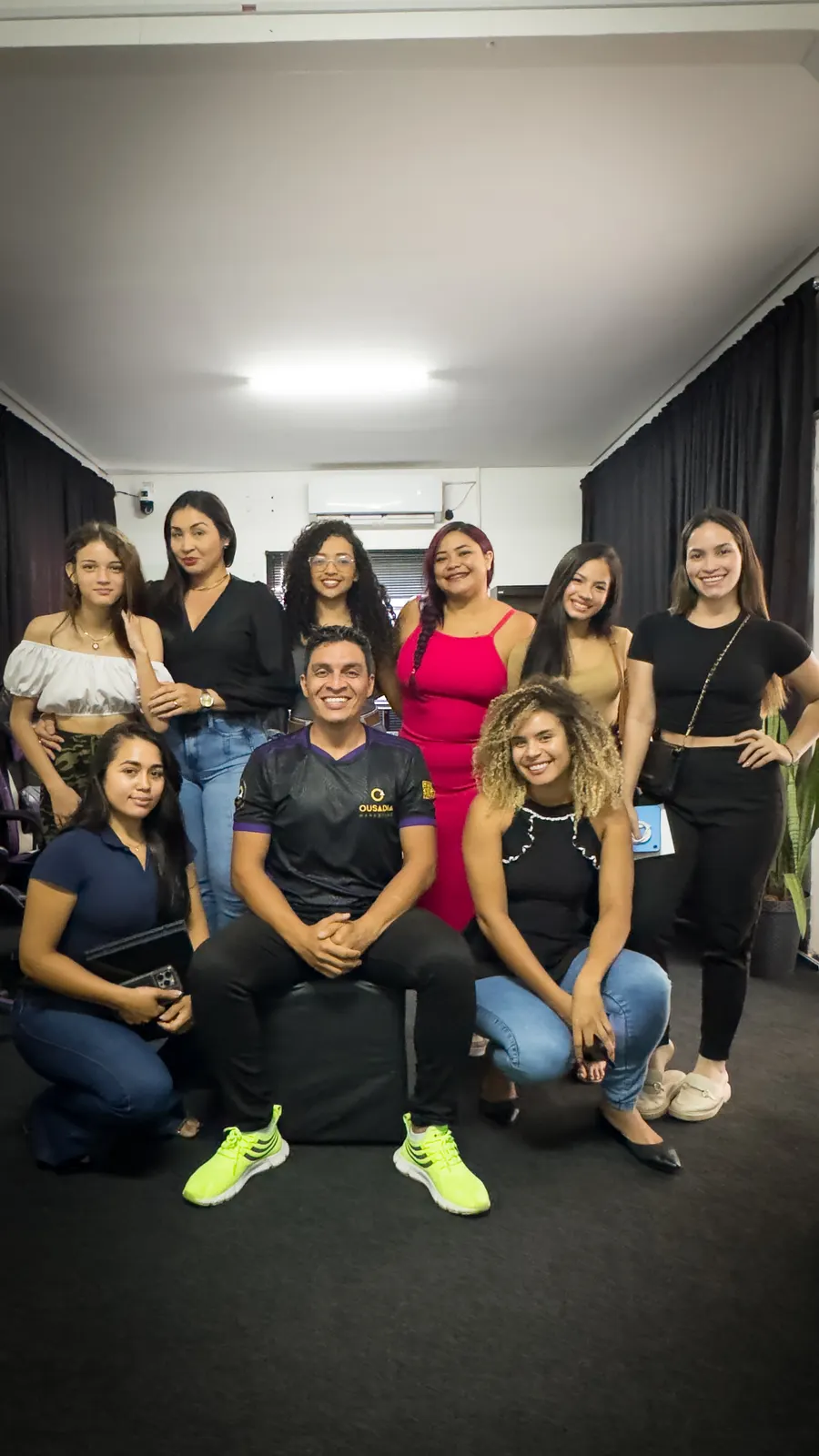Jackson com um grupo de alunas sorrindo na sala da Ousadia Marketing