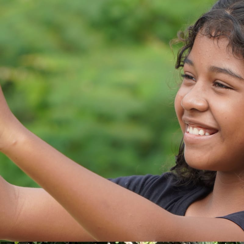 Menina fotografando com o celular durante a oficina