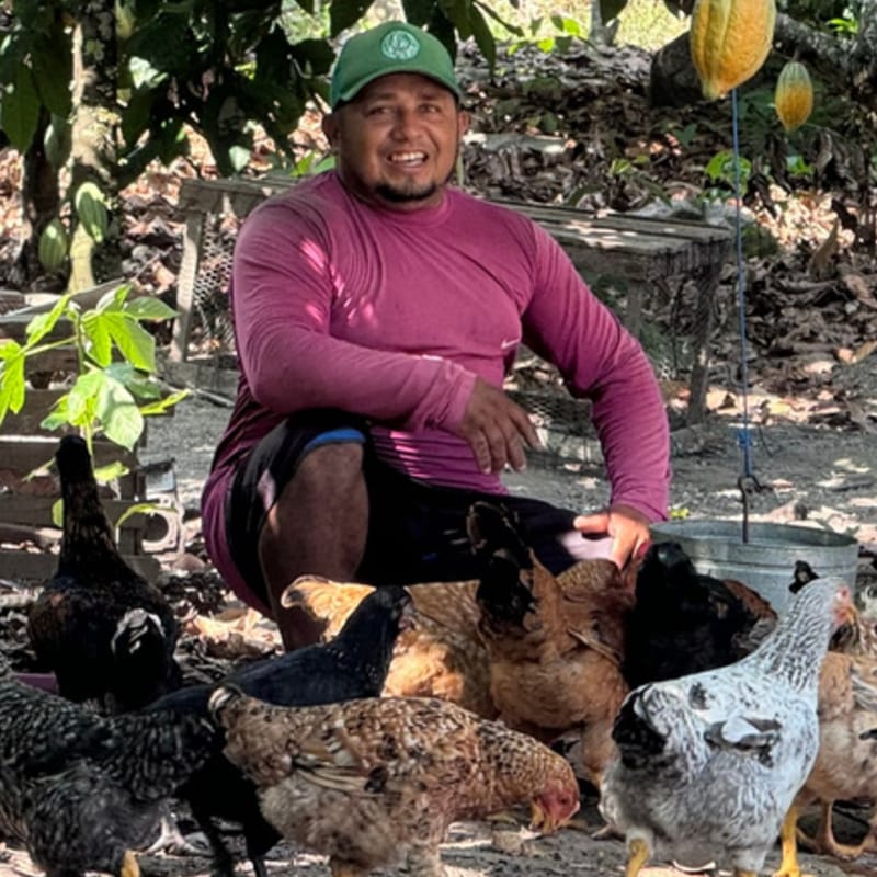 Produtora entre os cacaueiros, na comunidade