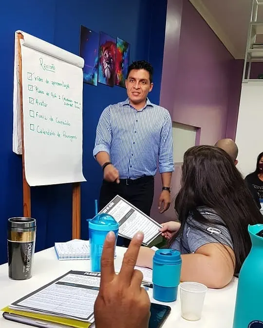 Jackson Queiroz dando aula diante de um flip chart com a revisão do dia